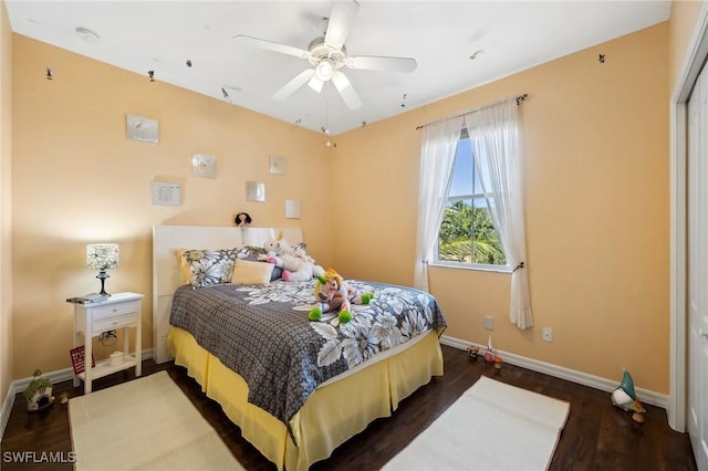 bedroom with ceiling fan, dark wood-type flooring, and baseboards