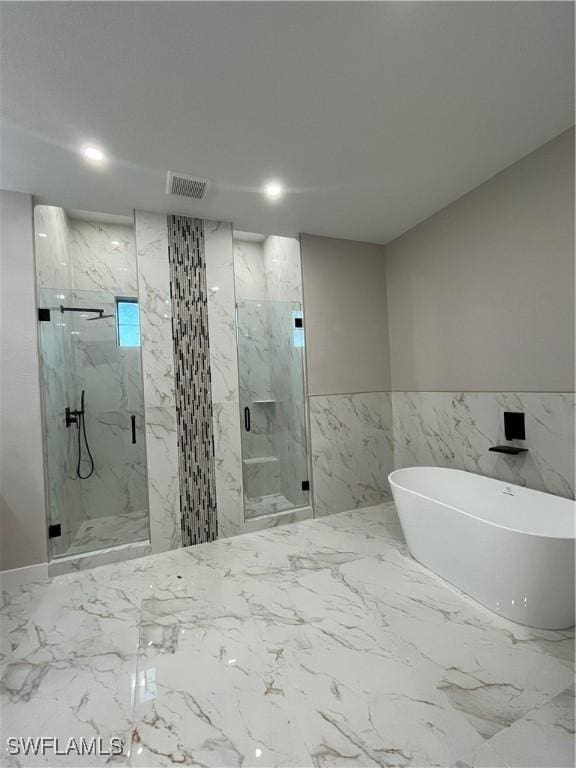 bathroom featuring separate shower and tub and tile walls