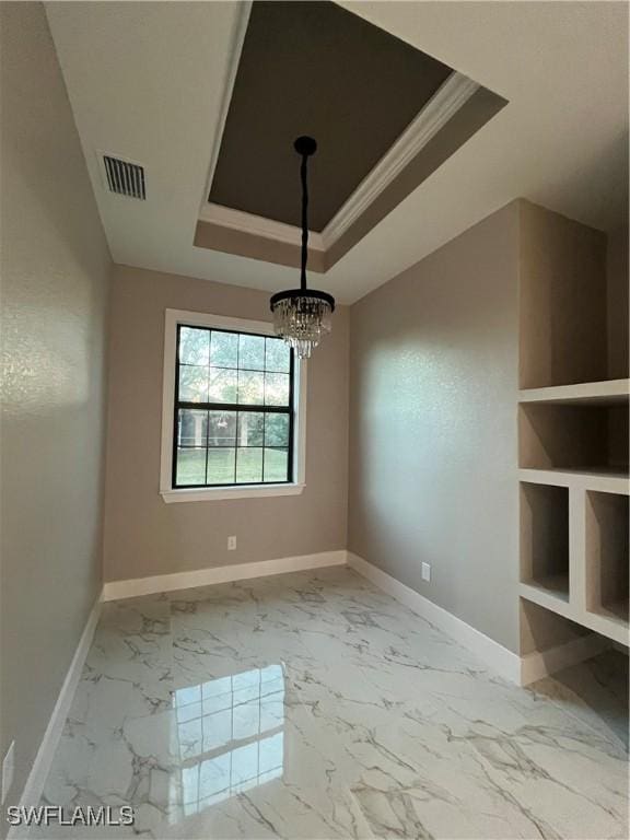 unfurnished dining area with a notable chandelier, ornamental molding, and a tray ceiling