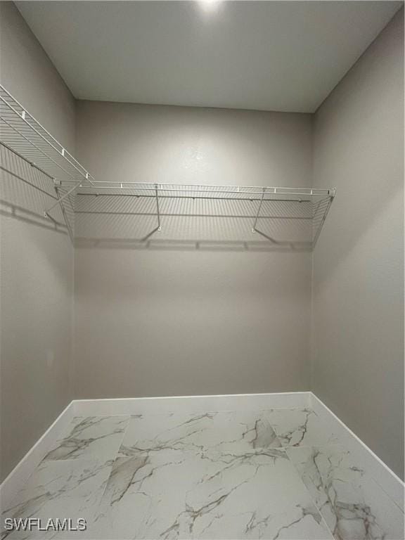spacious closet with marble finish floor