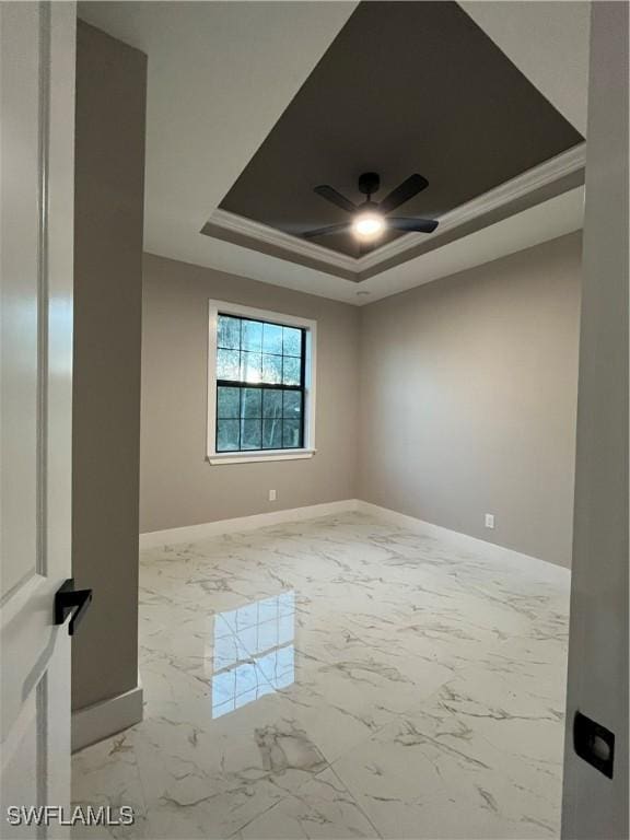 spare room featuring ceiling fan, ornamental molding, and a tray ceiling