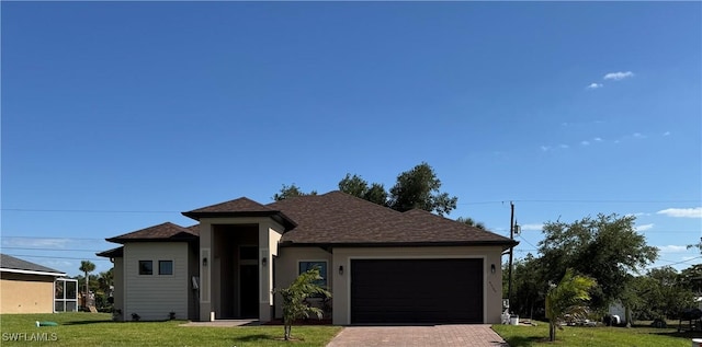 view of front of house featuring an attached garage, a front lawn, roof with shingles, and decorative driveway
