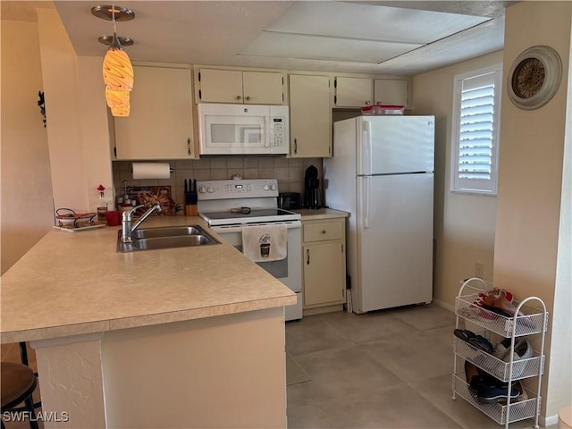 kitchen with sink, decorative light fixtures, cream cabinets, white appliances, and kitchen peninsula