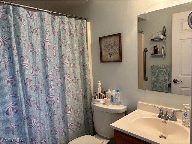 bathroom with toilet, a shower with shower curtain, and vanity