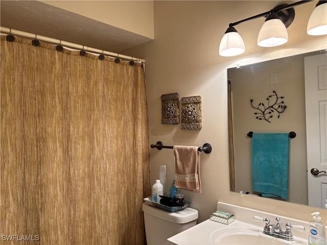 bathroom featuring toilet, curtained shower, and vanity