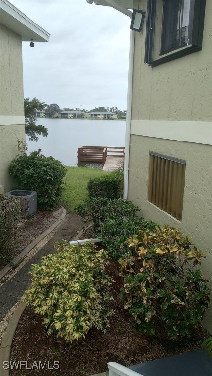 view of yard featuring a water view and central air condition unit