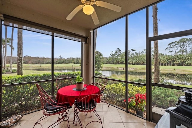 sunroom / solarium featuring ceiling fan and a water view