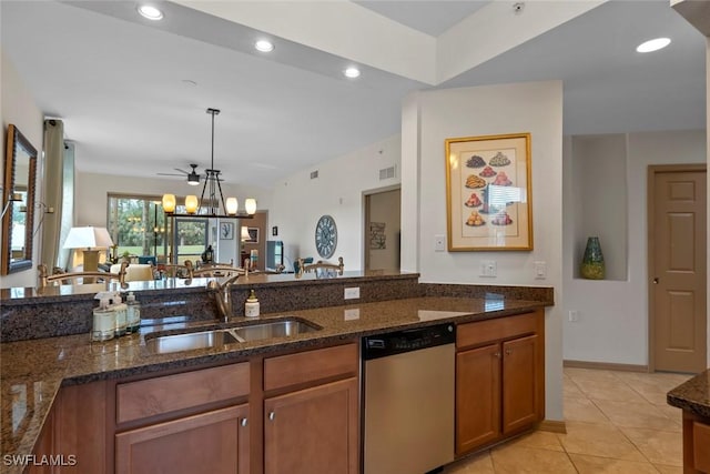 kitchen featuring stainless steel dishwasher, sink, pendant lighting, and dark stone counters