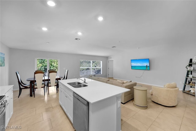 kitchen with white cabinets, sink, light tile patterned floors, an island with sink, and stainless steel appliances