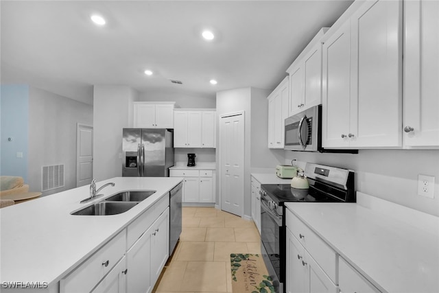 kitchen featuring light tile patterned flooring, stainless steel appliances, white cabinetry, and sink