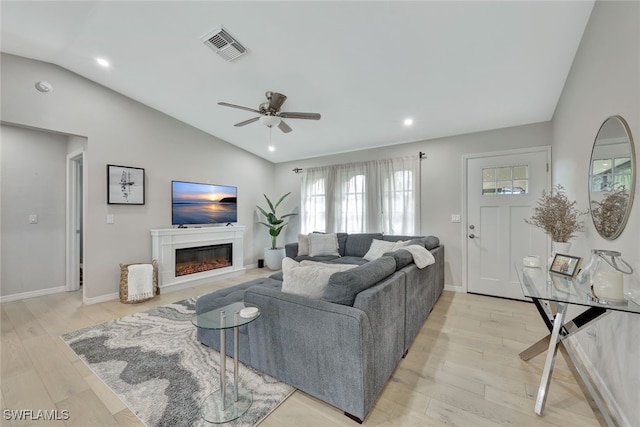 living room with lofted ceiling, ceiling fan, and light hardwood / wood-style floors