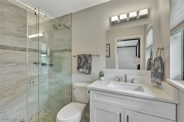 bathroom featuring an enclosed shower, vanity, and toilet