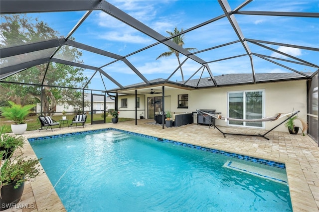 view of pool featuring ceiling fan, a patio area, and glass enclosure