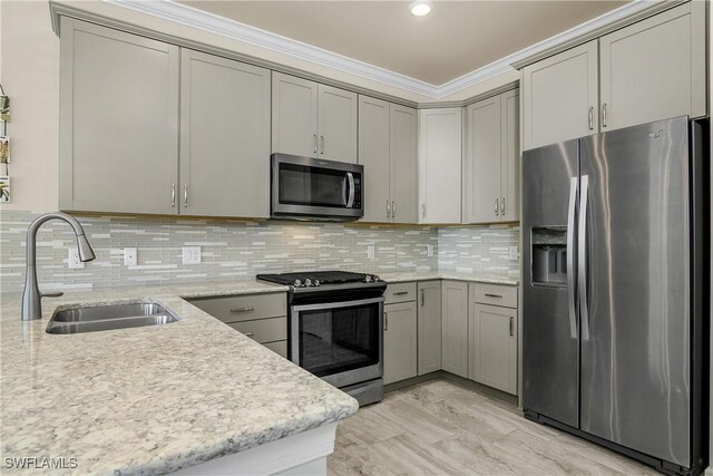 kitchen with stainless steel appliances, tasteful backsplash, sink, gray cabinets, and crown molding