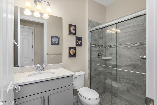 full bath featuring a stall shower, vanity, and toilet