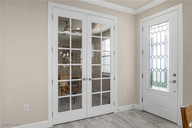 entrance foyer featuring a ceiling fan, baseboards, crown molding, and french doors