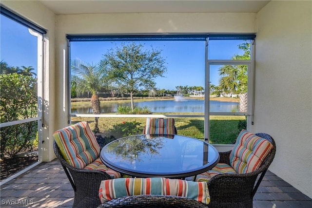 sunroom with plenty of natural light and a water view