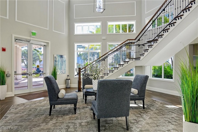 dining room with french doors, hardwood / wood-style floors, and a towering ceiling