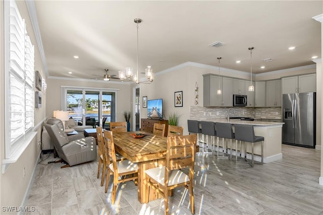 dining space with recessed lighting, ceiling fan with notable chandelier, visible vents, baseboards, and ornamental molding