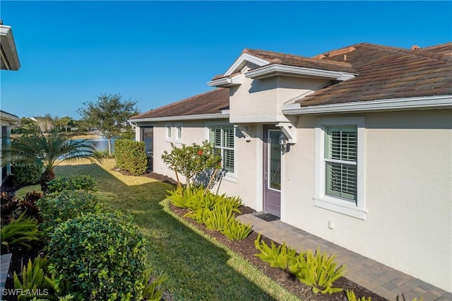 exterior space featuring a lawn and stucco siding