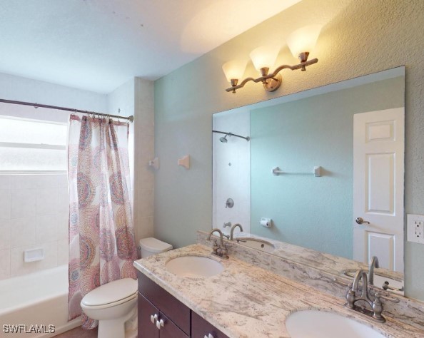 full bathroom with vanity, shower / bath combination with curtain, and toilet