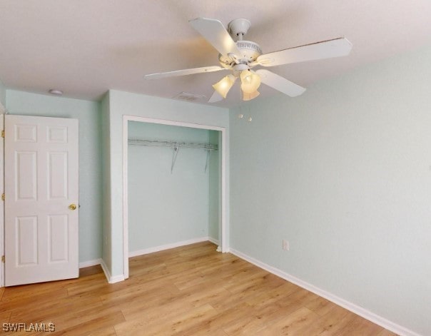 unfurnished bedroom with ceiling fan, light wood-type flooring, and a closet