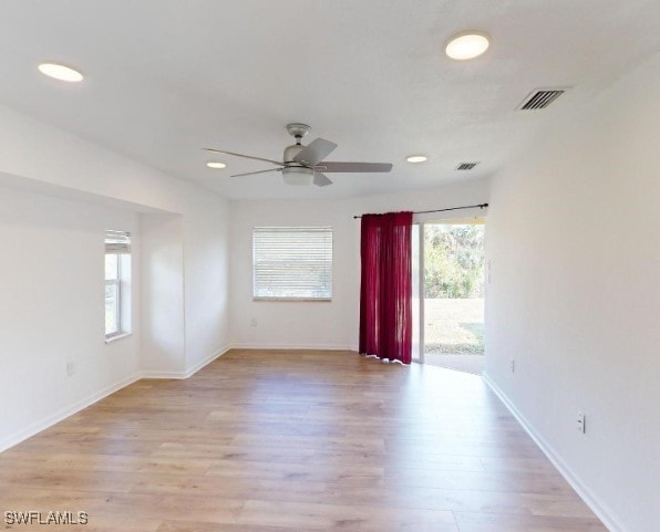 empty room with ceiling fan and light hardwood / wood-style flooring