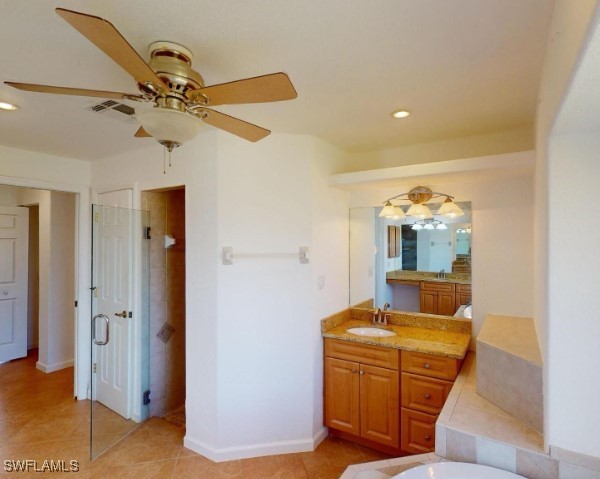 bathroom with tile patterned floors, ceiling fan, a bathtub, and vanity