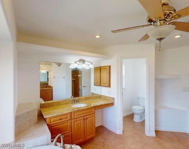 bathroom with tile patterned floors, vanity, ceiling fan, toilet, and a bathing tub