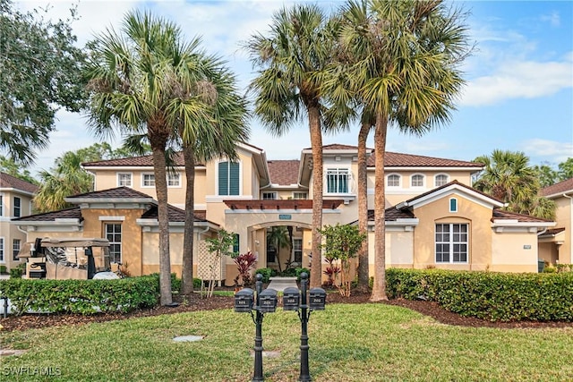 mediterranean / spanish-style home with a front yard