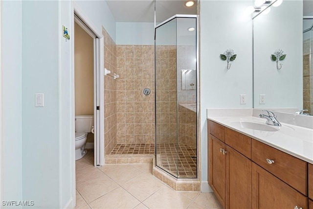 bathroom featuring vanity, toilet, a shower with door, and tile patterned flooring