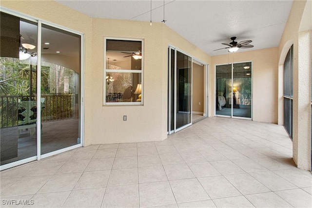 unfurnished sunroom featuring ceiling fan