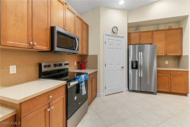 kitchen featuring stainless steel appliances, tasteful backsplash, and light tile patterned floors