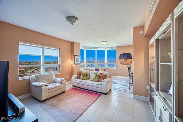 living room with a textured ceiling and light tile patterned floors