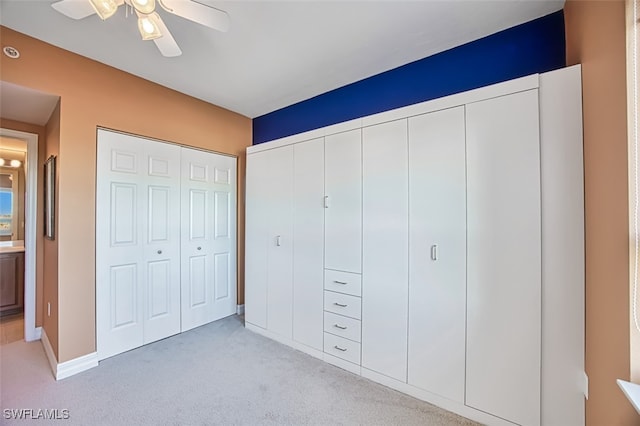 unfurnished bedroom featuring light carpet, ceiling fan, and a closet