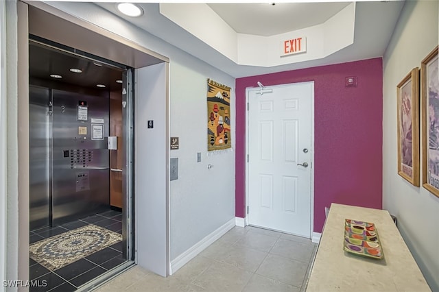 corridor with light tile patterned floors and elevator