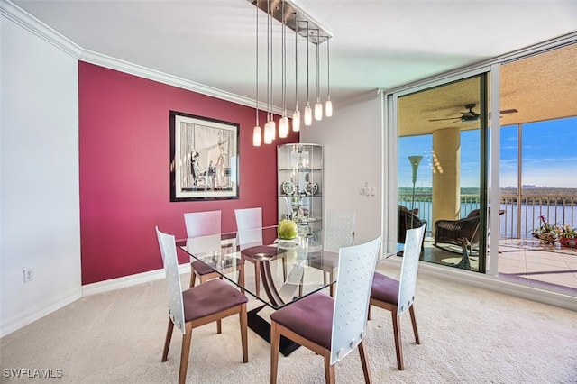 dining room featuring a water view, crown molding, carpet floors, expansive windows, and ceiling fan