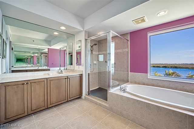 bathroom featuring a water view, vanity, independent shower and bath, a healthy amount of sunlight, and tile patterned flooring