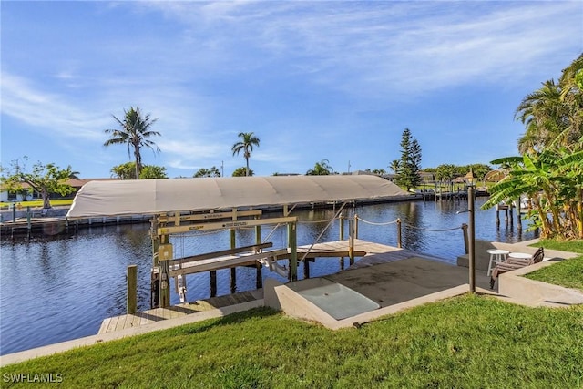 view of dock with a lawn and a water view