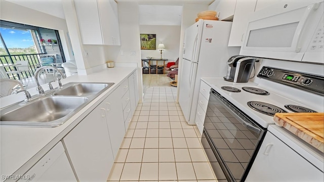 kitchen with sink, white appliances, light tile patterned floors, and white cabinets