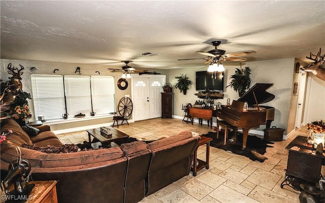 living room with a textured ceiling and ceiling fan