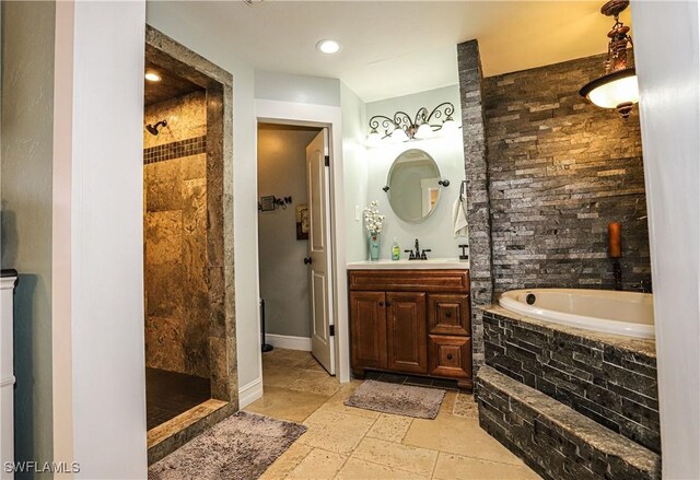 bathroom with vanity and shower with separate bathtub