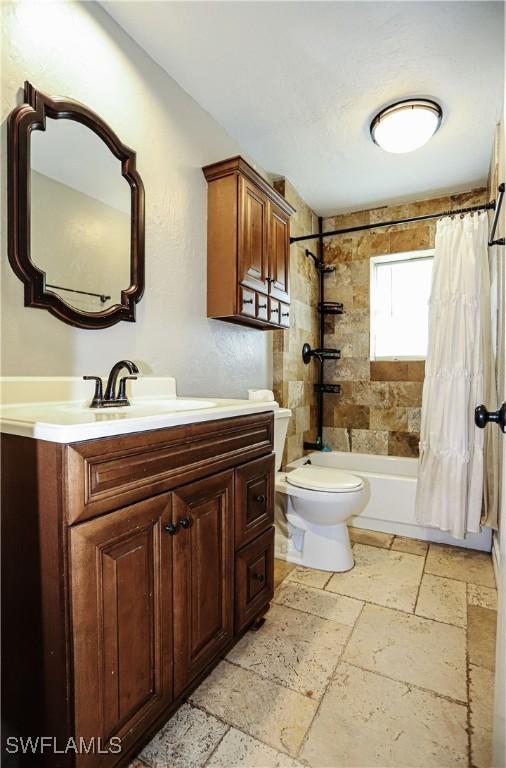 full bathroom with shower / bath combination with curtain, vanity, and toilet