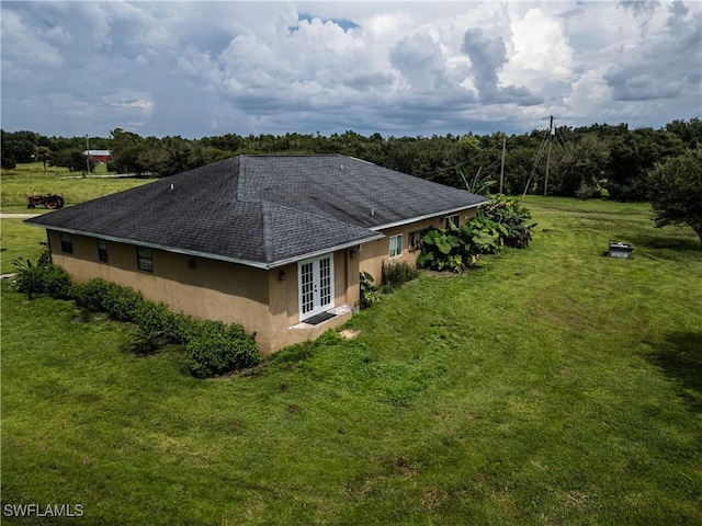 view of home's exterior featuring a lawn and french doors