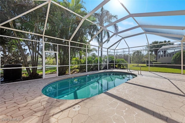 view of swimming pool featuring glass enclosure and a patio