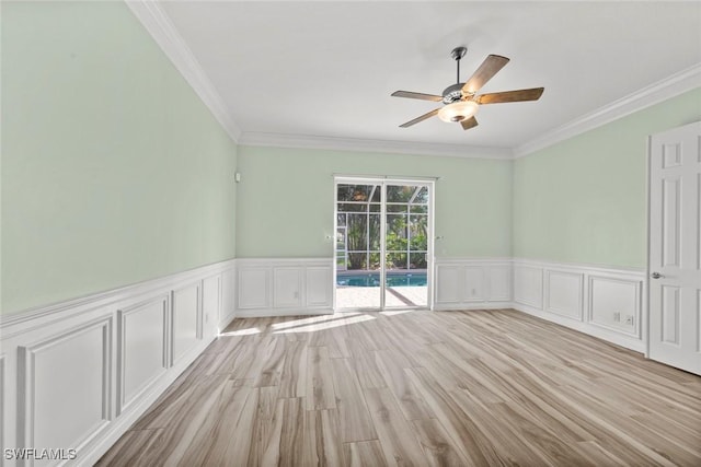 spare room featuring ceiling fan, light wood-type flooring, and ornamental molding