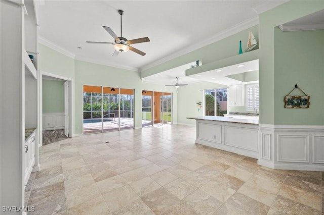 kitchen with white cabinetry, ornamental molding, and plenty of natural light