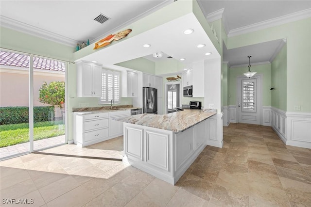 kitchen with white cabinetry, appliances with stainless steel finishes, ornamental molding, and kitchen peninsula