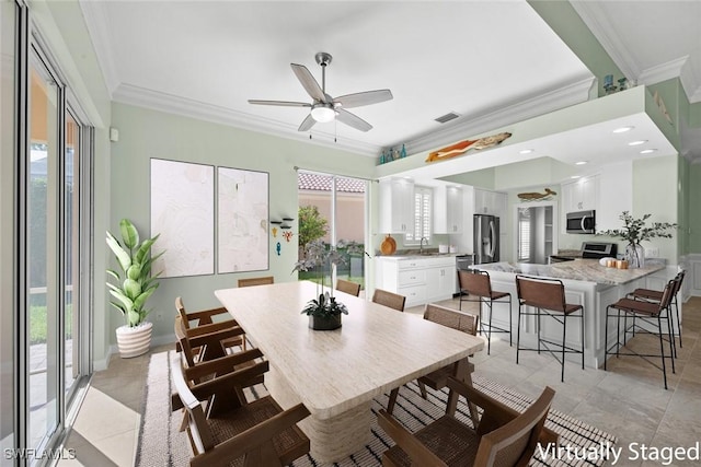 dining area featuring ceiling fan, sink, and ornamental molding