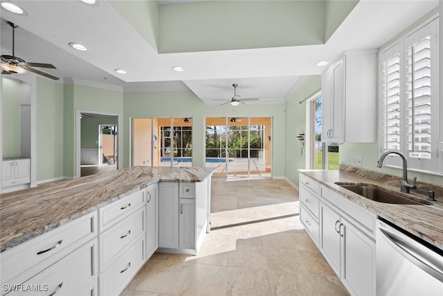 kitchen with light stone countertops, sink, white cabinetry, and stainless steel dishwasher